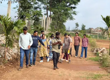 Visitors walking through the farmland during a guided visit at Girivanam Farms